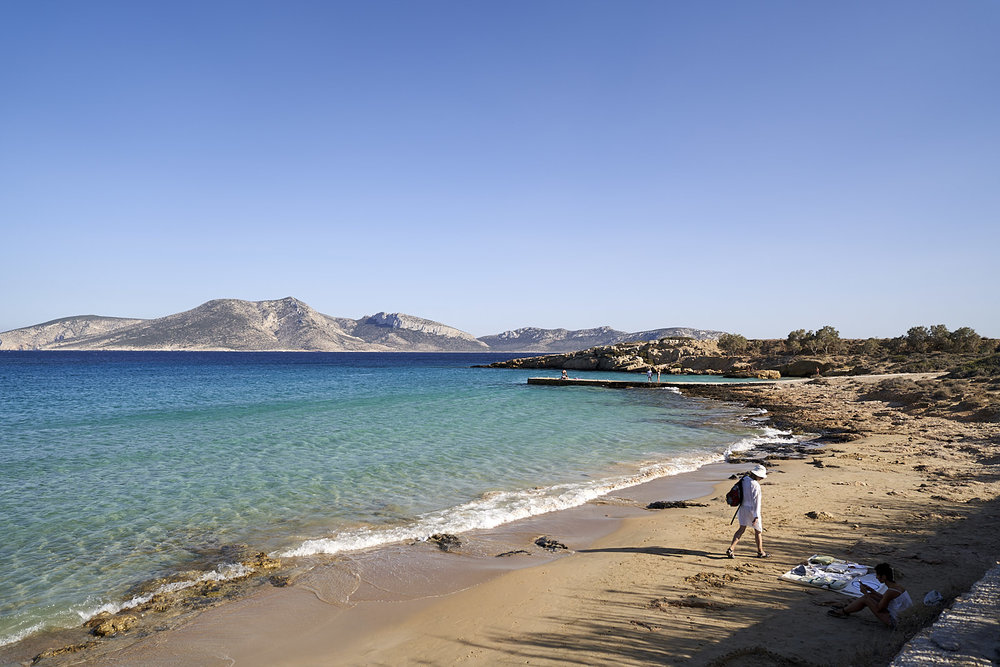 A woman walks on the beach in Koufonisia, Greece